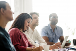 Stock image of staff attending a meeting.