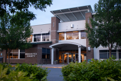 Exterior of Deschutes Services Building with trees and greenery in foreground