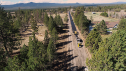 Aerial view of road paving on Tumalo Reservoir Road through a rural area.