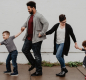 Family with two children holding hands. 